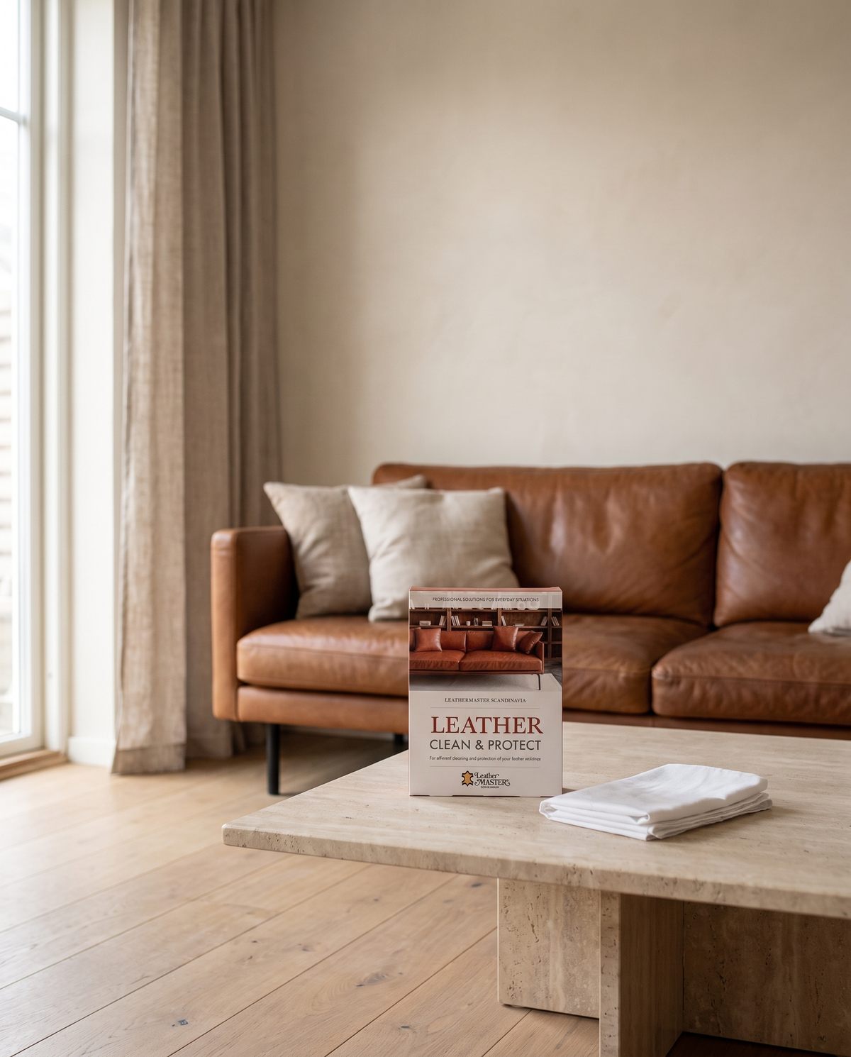 Lädersoffa i konjak med Leather Clean & Protect på soffbordet